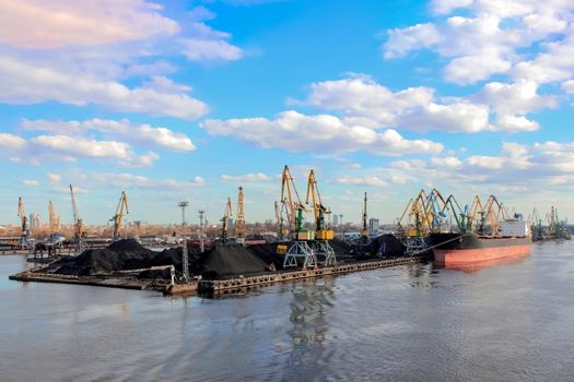 Baltic coal terminal with port cranes near the river. Riga cargo