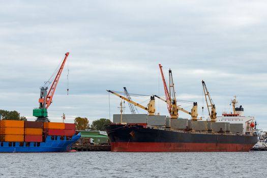 Black cargo ship loading in the port of Riga, Europe