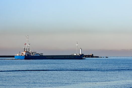 Blue cargo ship leaving Riga and entering Baltic sea