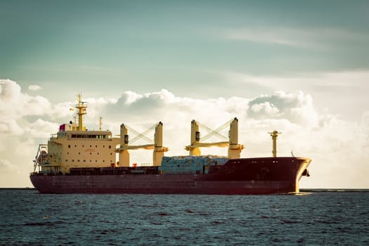 Red cargo ship moving entering the port of Riga