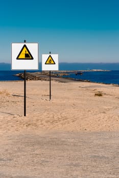 Yellow warning signs on summer beach, Riga