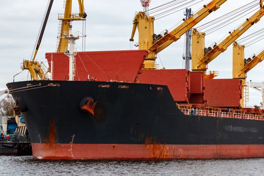 Black cargo ship loading in the port of Riga, Europe