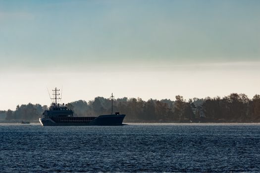 Blue cargo ship leaving Riga and entering Baltic sea