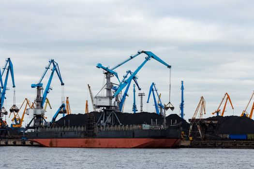 Black barge loading in cargo port of Riga