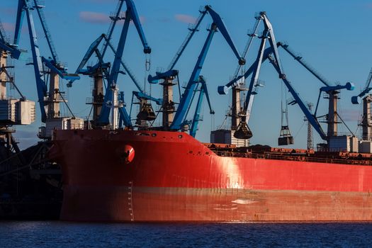 Red cargo ship loading in the port of Riga, Europe