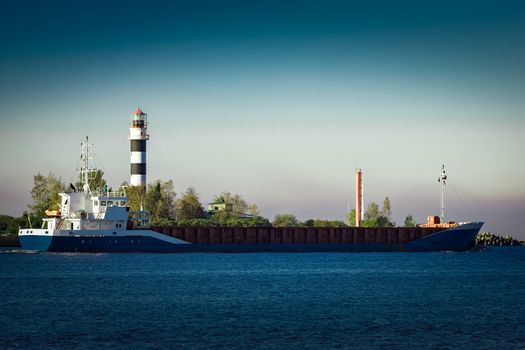 Blue cargo ship leaving Riga and entering Baltic sea