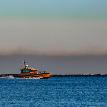 Orange pilot ship sailing from the Baltic sea in Latvia