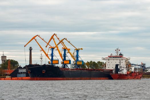 Black cargo ship loading in the port of Riga, Europe