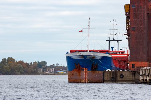 Blue cargo ship loading in the port of Riga, Europe