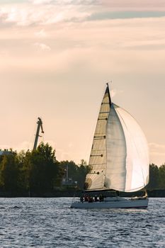 Sailboat moving on Daugava river in evening, Latvia