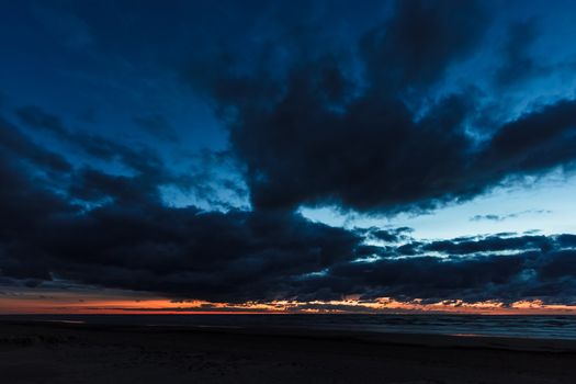 Dark blue cloudy sky over the Baltic sea at night