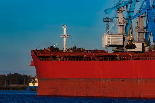 Red cargo ship loading in the port of Riga, Europe