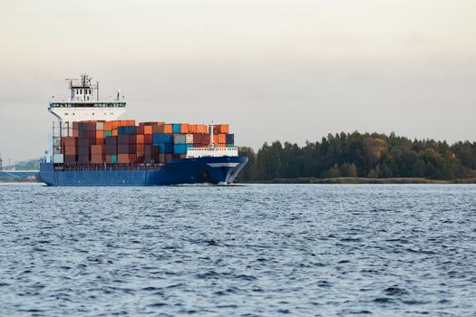 Blue container ship moving to Baltic sea. Riga, Latvia