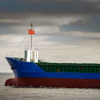 Blue cargo ship's bow leaving the port of Riga