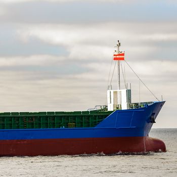 Blue cargo ship's bow leaving the port of Riga