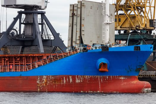 Blue cargo ship loading in the port of Riga, Europe