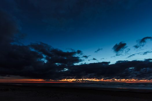 Dark blue cloudy sky over the Baltic sea at night