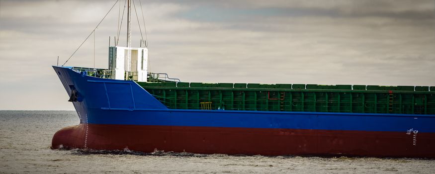 Blue cargo ship's bow leaving the port of Riga