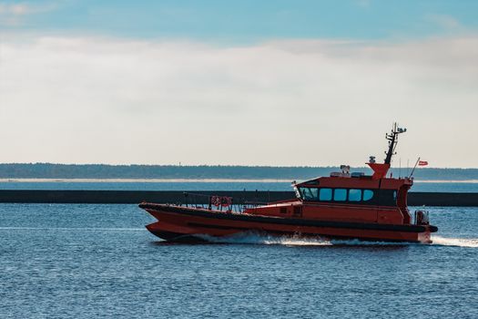 Orange pilot ship moving fast from Baltic sea