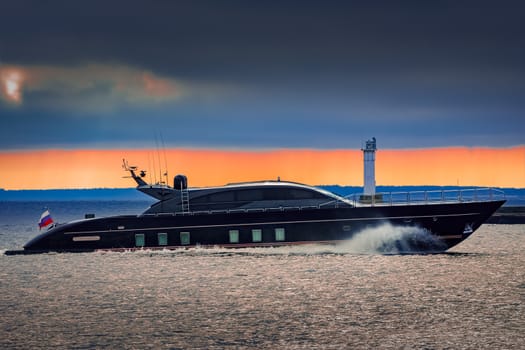 Black elite speed motor boat moving fast from Baltic sea