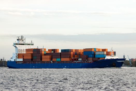 Blue container ship moving to Baltic sea. Riga, Latvia