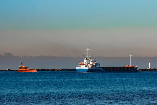 Blue cargo ship leaving Riga and entering Baltic sea