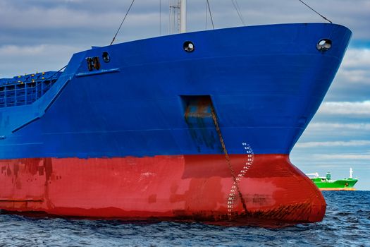 Blue cargo ship moored in still Baltic sea water