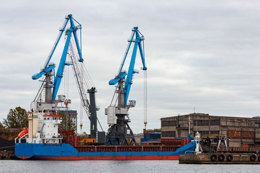 Blue cargo ship loading in the port of Riga, Europe