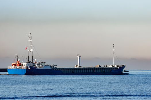 Blue cargo ship leaving Riga and entering Baltic sea