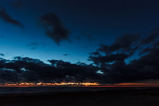 Dark blue cloudy sky over the Baltic sea at night