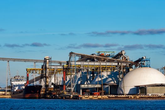 Black cargo ship loading in the port of Riga, Europe