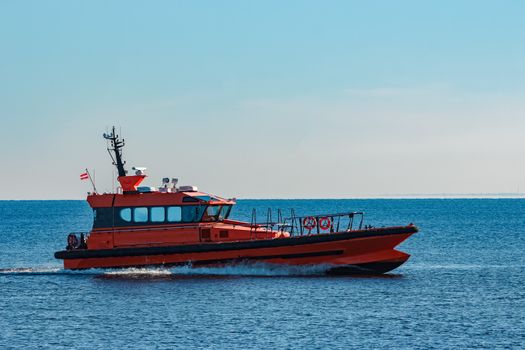 Orange pilot ship moving fast from Baltic sea