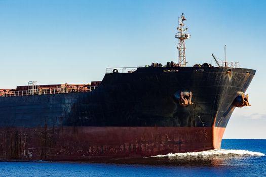 Black cargo ship's bow in still water. Riga, Europe