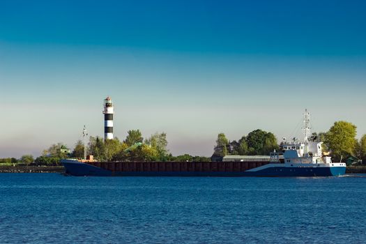 Blue cargo ship leaving Riga and entering Baltic sea