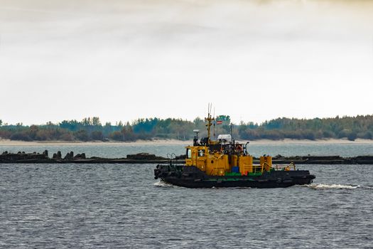 Small orange tug ship moving from the Baltic sea