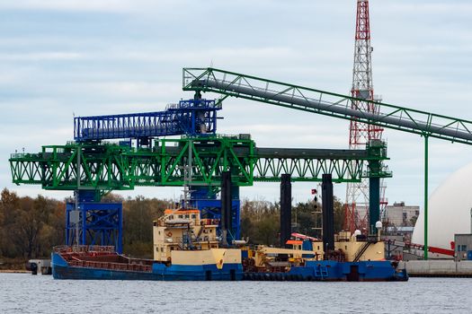 Blue cargo ship loading in the port of Riga, Europe