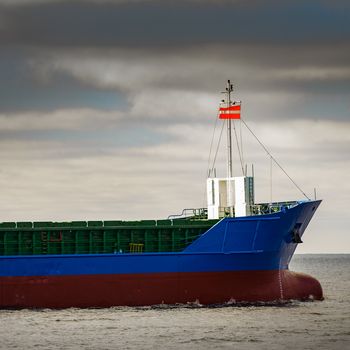 Blue cargo ship's bow leaving the port of Riga