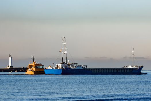 Blue cargo ship leaving Riga and entering Baltic sea