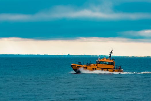 Orange pilot ship moving fast in Baltic sea. Europe