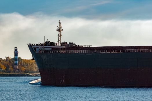 Black cargo ship's bow entering Riga, Europe