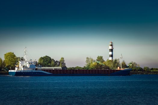 Blue cargo ship leaving Riga and entering Baltic sea