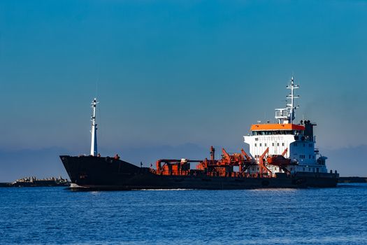 Black cargo oil tanker sailing in still water from Baltic sea