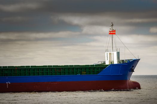 Blue cargo ship's bow leaving the port of Riga