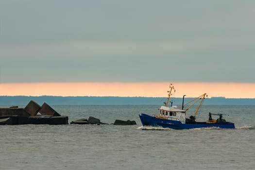 Blue fishing ship sailing in stll water