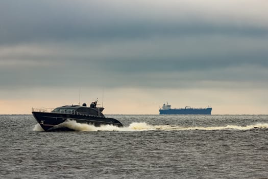 Black elite speed motor boat moving fast from Baltic sea