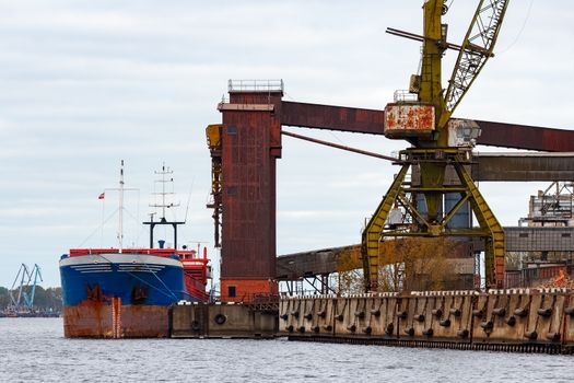 Blue cargo ship loading in the port of Riga, Europe