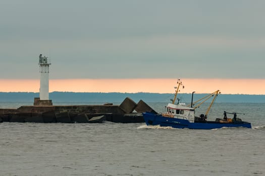 Blue fishing ship sailing in stll water