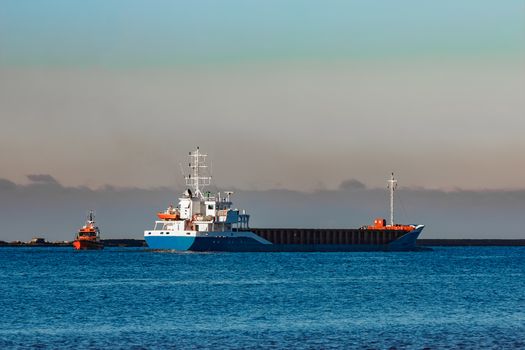 Blue cargo ship leaving Riga and entering Baltic sea