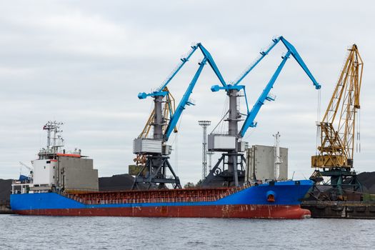 Blue cargo ship loading in the port of Riga, Europe