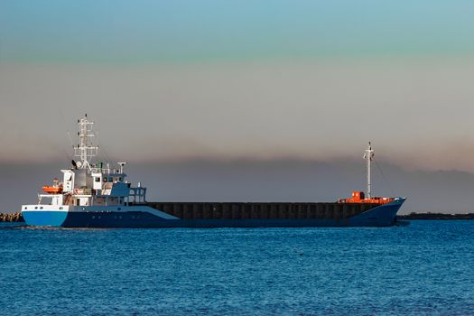 Blue cargo ship leaving Riga and entering Baltic sea